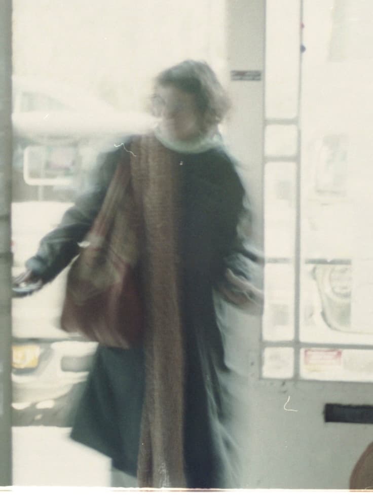 A blurry image of Karina walking through a door
