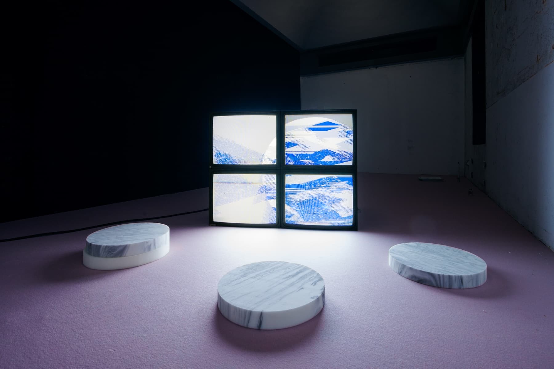 A room with four screens showing blue skies. 