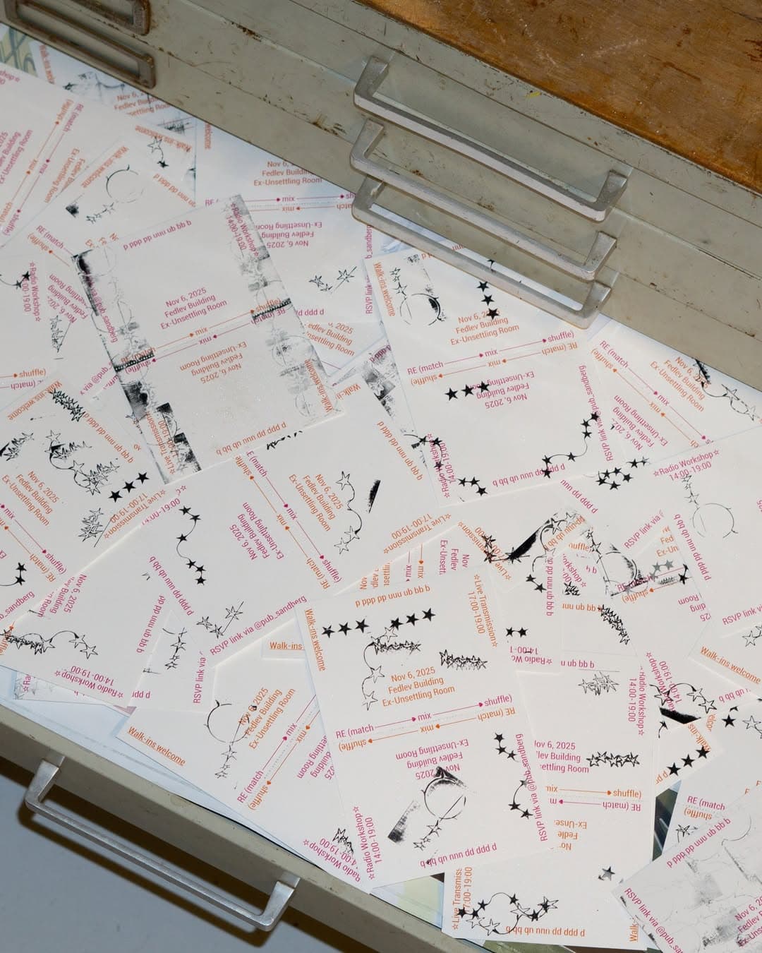 The image shoes dozens of leaflets in an open drawer. The leaflets advertise an event in November 2025.